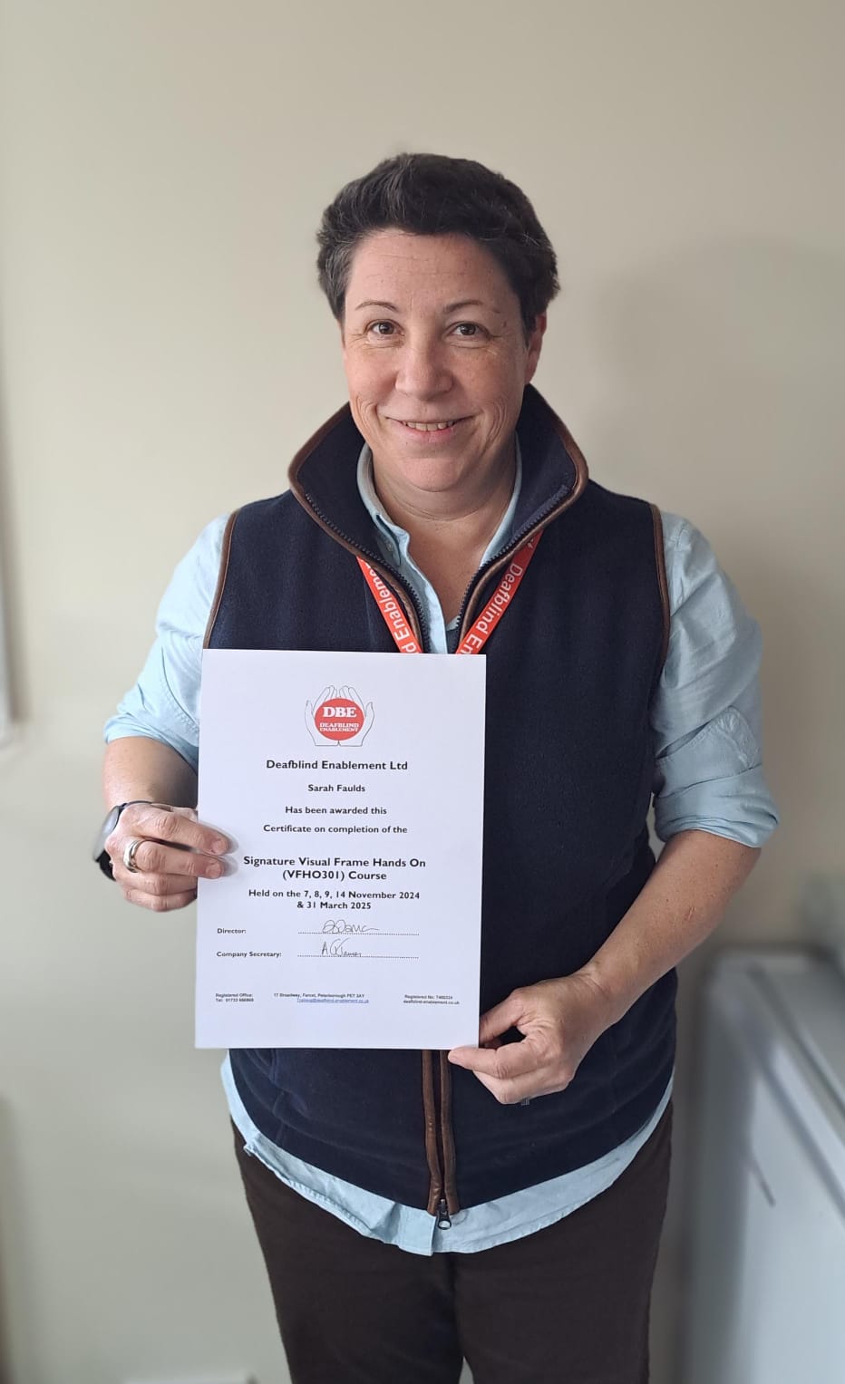 Sarah holding their certificate